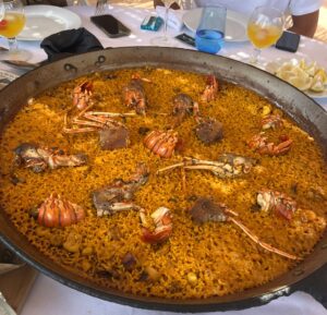 Paella de langosta recién hecha servida en paellera tradicional en el restaurante La Dehesa en El Saler, Valencia.